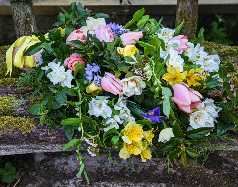 A Hand Tied Sheaf Bouquet of British grown Spring flowers & foliage for a funeral. Copyright www.GallowayFlowers.co.uk